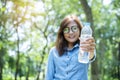 Happiness Beautiful asian chinese women holding mineral water bottle. Young Woman Drinking Water from bottle in green garden Park Royalty Free Stock Photo