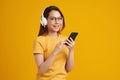 Happiness Beautiful Asian smiling young woman wearing technology wireless  headphones for listening the music via smart mobile Royalty Free Stock Photo