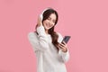 Happiness Beautiful Asian smiling young woman wearing technology wireless  headphones for listening the music via smart mobile Royalty Free Stock Photo