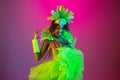 Beautiful young woman in carnival and masquerade costume on gradient studio background in neon light Royalty Free Stock Photo