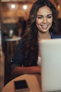 Happiness is bottomless wifi. a relaxed young woman using her laptop in a coffee shop.