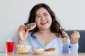 Happiness closeup shot of Asian young happy beautiful hungry overweight fat chubby female smile at camera hold chocolate donut in