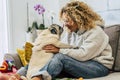 Happiness concept with cheerful adult single woman hug a funny pug dog kiss her on the nose - adorable friendship with animal and