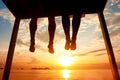 Happiness concept, silhouette of feet of couple sitting on the pier on beach Royalty Free Stock Photo