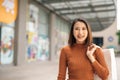 Happiness, consumerism, sale and people concept - smiling young Asian woman with shopping bags at outdoor shopping mall Royalty Free Stock Photo