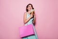 Happiness, consumerism, sale and people concept - smiling young woman with shopping bag over pink background Royalty Free Stock Photo