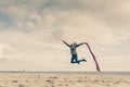 Happy woman jumping with scarf on beach Royalty Free Stock Photo