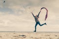 Happy woman jumping with scarf on beach Royalty Free Stock Photo