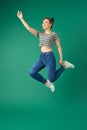 Happiness, freedom, motion and people concept - smiling young woman jumping in air over green background Royalty Free Stock Photo