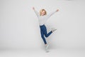 Happiness, freedom, movement and people concept. Smiling young woman jumping in air isolated on gray background Royalty Free Stock Photo