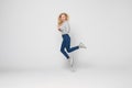 Happiness, freedom, movement and people concept. Smiling young woman jumping in air isolated on gray background Royalty Free Stock Photo