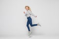 Happiness, freedom, movement and people concept. Smiling young woman jumping in air isolated on gray background Royalty Free Stock Photo