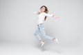 Happiness, freedom, power, motion and people concept - smiling young woman jumping in air with raised fists over white background Royalty Free Stock Photo