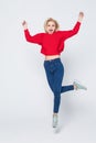 Happiness, freedom, power, motion and people concept. Smiling young woman jumping in air with raised fists over white background Royalty Free Stock Photo