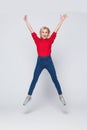 Happiness, freedom, power, motion and people concept. Smiling young woman jumping in air with raised fists over white background Royalty Free Stock Photo