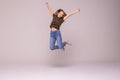 Smiling young woman jumping in air with raised fists over white background Royalty Free Stock Photo