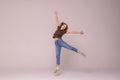 Smiling young woman jumping in air with raised fists over white background Royalty Free Stock Photo