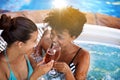 Happiness is a glass of champagne. Cropped shot of two young women enjoying a glass of champagne in a jacuzzi. Royalty Free Stock Photo