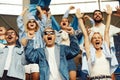 Happiness. Group of sport fans, enthusiasts, people cheering up favourite team during football match Royalty Free Stock Photo