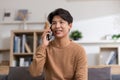 Happiness handsome asian young man smiling talking with girlfriend on mobile phone at home. Attractive charming teenager holds Royalty Free Stock Photo
