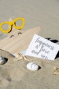 HAPPINESS IS HERE AND NOW text on paper greeting card on background of funny starfish in glasses summer vacation decor Royalty Free Stock Photo