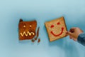 Happiness lifestyle concept. Flat Lay of Sliced Toasted Bread. Person Picked a Well Done Piece with Smiling Face. the Burned one