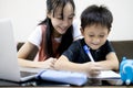 Happiness little brother studying with big sister at home,kid writing a book,smiling girl is teaching,helping and child boy Royalty Free Stock Photo