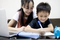 Happiness little brother studying with big sister at home,kid writing a book,smiling girl is teaching,helping and child boy