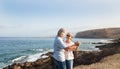 Happiness and love for a senior couple dancing  on the cliff of the ocean and looking each other in the eyes. Horizon over water Royalty Free Stock Photo
