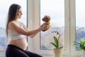 Pregnant young happy woman with toy teddy bear, at home near window Royalty Free Stock Photo