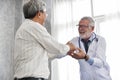 Senior male Doctor and Asian male patient are talking. Royalty Free Stock Photo