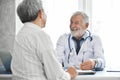 Senior male Doctor and Asian male patient are talking. Royalty Free Stock Photo