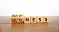 Happiness or sadness symbol. Turned cubes and changed the word `sadness` to `happiness`. Beautiful wooden table, white backgro