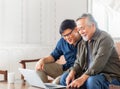 Happiness senior asian father and adult son using laptop talking on video call in living room Royalty Free Stock Photo