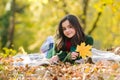 Happiness teenage outdoor on the autumn field. Teen girl lying on autumn maple leaves at fall outdoors. Beautiful fall Royalty Free Stock Photo