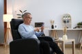 Happiness of wellness elderly asian man with white hairs sitting on sofa using mobile phone