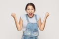 Happiness woman in denim overalls rejoicing for his success. Iso Royalty Free Stock Photo