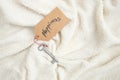 Happiness word, handwritten on a price tag key chain, on a soft furry blanket