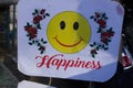 HAPPINESS WRITTEN ON A SMALL BOARD WITH A SMILEY FACE.