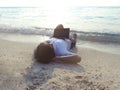 Happiness young Asian man with laptop lying on sandy of beach. Summer vacations concept Royalty Free Stock Photo