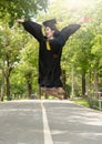 Happiness Young asian woman student in her graduation gown and wearing graduation cap with certificate in hands.Young female happy Royalty Free Stock Photo