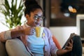 Happiness young entrepreneur woman using her smart phone while drinking a cup of coffee sitting on couch in the office Royalty Free Stock Photo