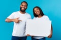 Happu black couple holding pointing at blank white advertising placard Royalty Free Stock Photo