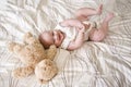 Happy 7 month old baby lying next to teddy bear