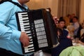 Happy accordion musician playing at wedding reception, hand on h Royalty Free Stock Photo