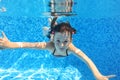 Happy active child swims underwater in pool