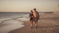 Happy active and healthy mature couple walking on the beach enjoying outdoors lifestyle Royalty Free Stock Photo