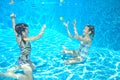 Happy active kids swim in pool and play underwater