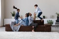 Happy active little sibling kids jumping high on home couch Royalty Free Stock Photo