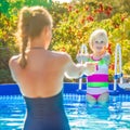 Happy active mother and daughter in swimming pool playing Royalty Free Stock Photo